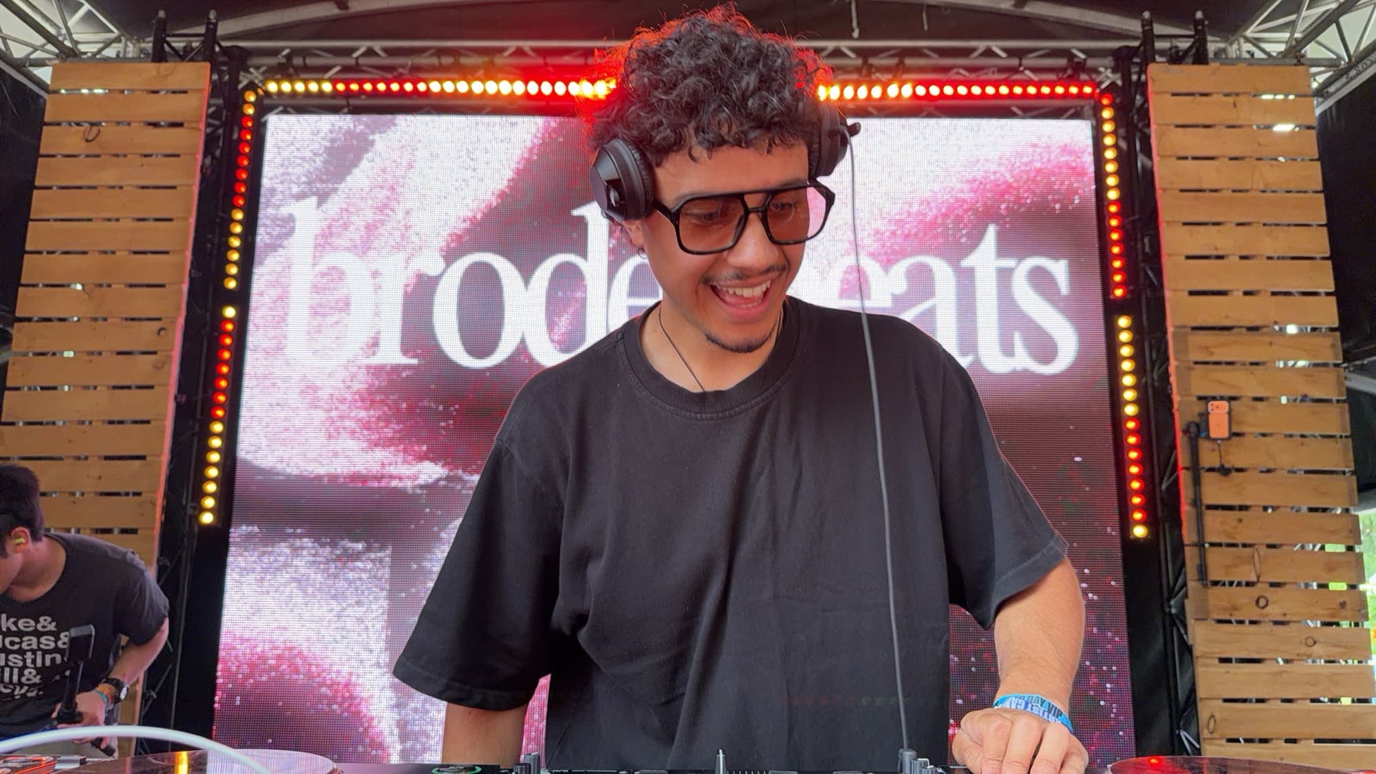 A DJ in headphones grinning at the decks
